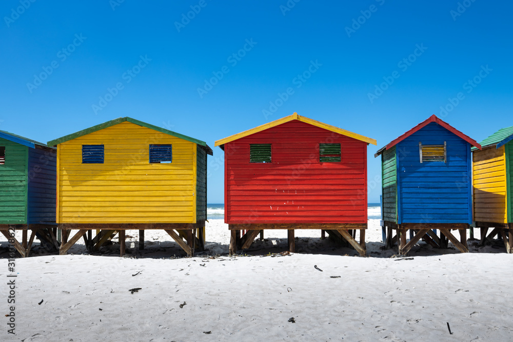 Naklejka premium The colored cabins in Muizenberg beach near Cape Town, South Africa, known for its wooden houses painted in vibrant colors