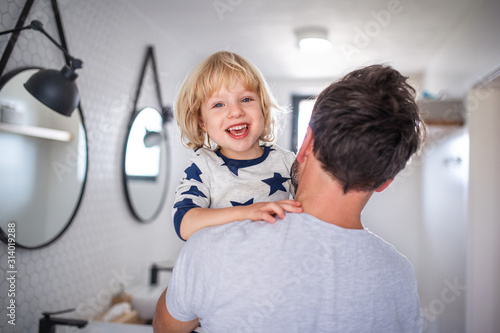 Mature father with small son indoors in bathroom  having fun.