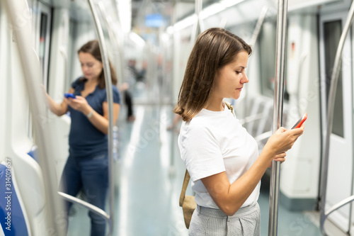 Woman with phone traveling in subway car