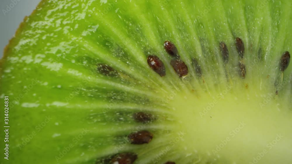 Macro view of sliced kiwi slowly rotating viewing the vibrant green color and seeds. Macro view of sliced kiwi slowly rotating viewing the vibrant green color and seeds.