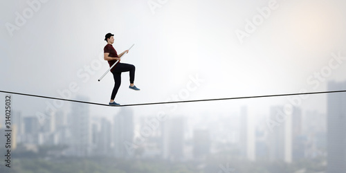 Brave ropewalker on cable. Mixed media photo