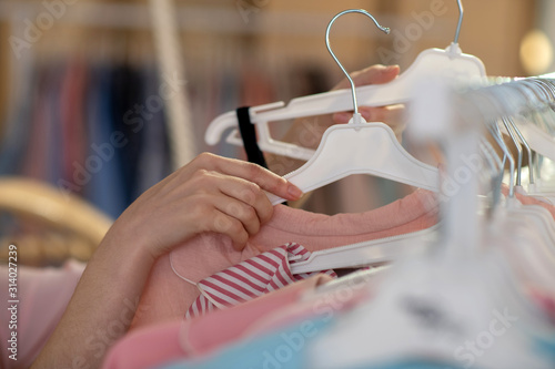 Consultant's hands removing and outweighing trempels with women's clothing.
