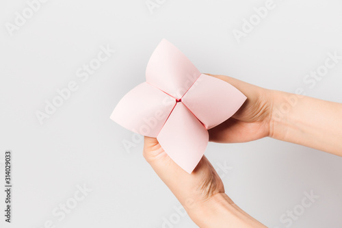 Hand in a paper fortune teller isolated on white background.
