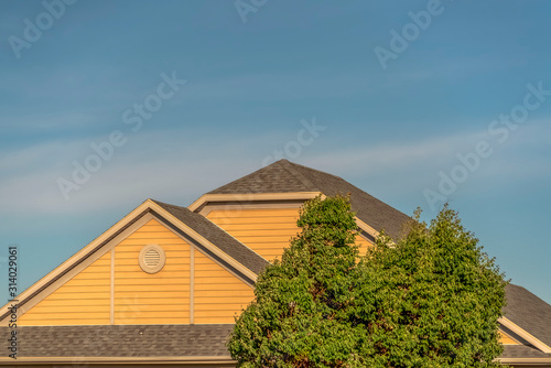 Exterior front view of home with focus on the roof against sky on a sunny day