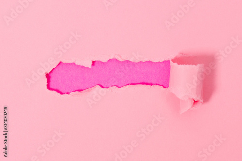 Top view of pink torn paper on pink background.