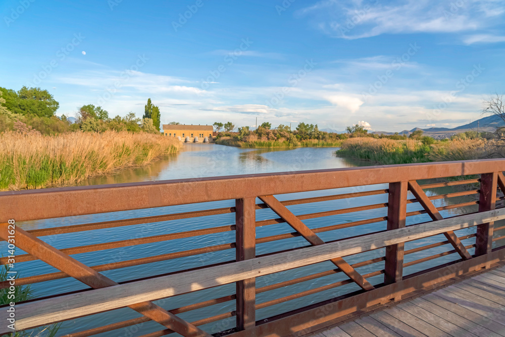 Lake with grassy shore against buildings mountain and sky viewed from a bridge Lake with grassy shore against buildings mountain and sky viewed from a bridge