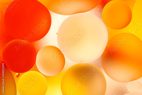 bright oily drops in water with colorful background, close-up 