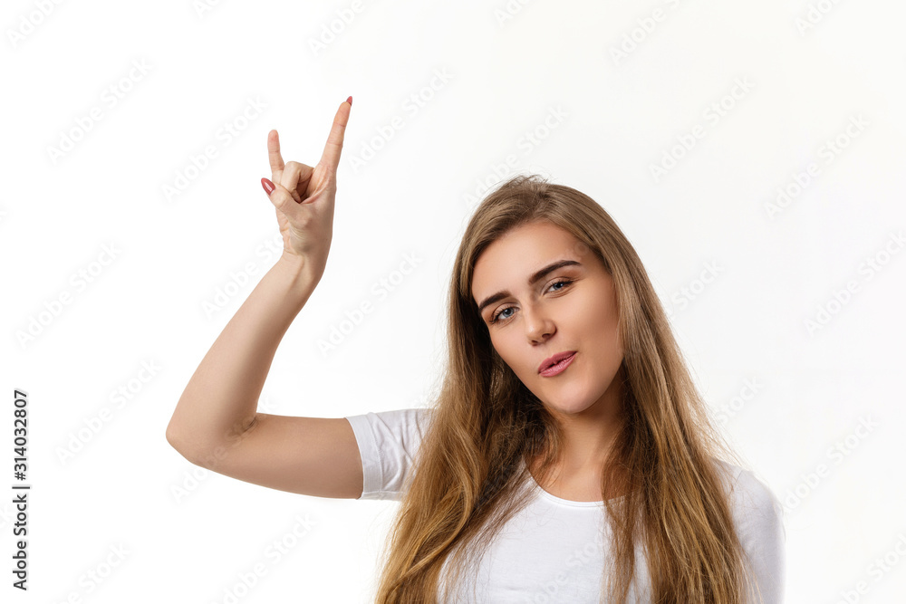 smiling young woman showing rock and roll hand and looking at camera on white background. smiling young woman showing rock and roll hand and looking at camera on white background.