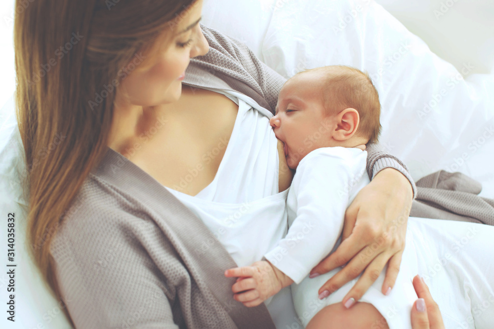 A woman is breastfeeding a baby. A woman is breastfeeding a baby.