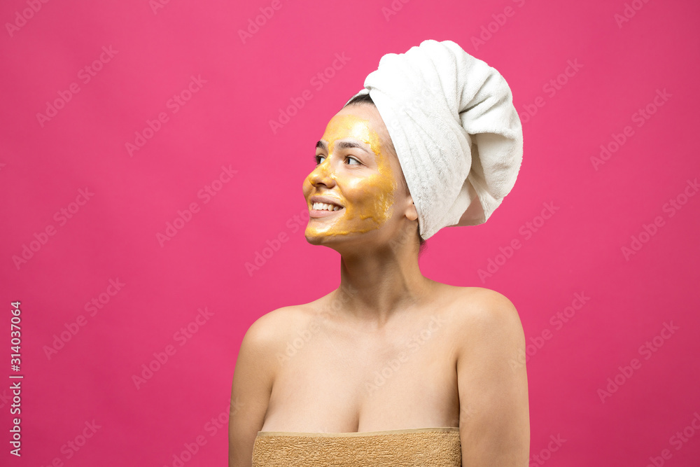 Beauty portrait of woman in white towel on head with gold nourishing mask on face. Skincare cleansing eco organic cosmetic spa relax concept. Beauty portrait of woman in white towel on head with gold nourishing mask on face. Skincare cleansing eco organic cosmetic spa relax concept.