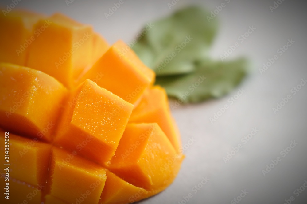 Mango tropical fruit with green leaf on abstract background, top view Mango tropical fruit with green leaf on abstract background, top view