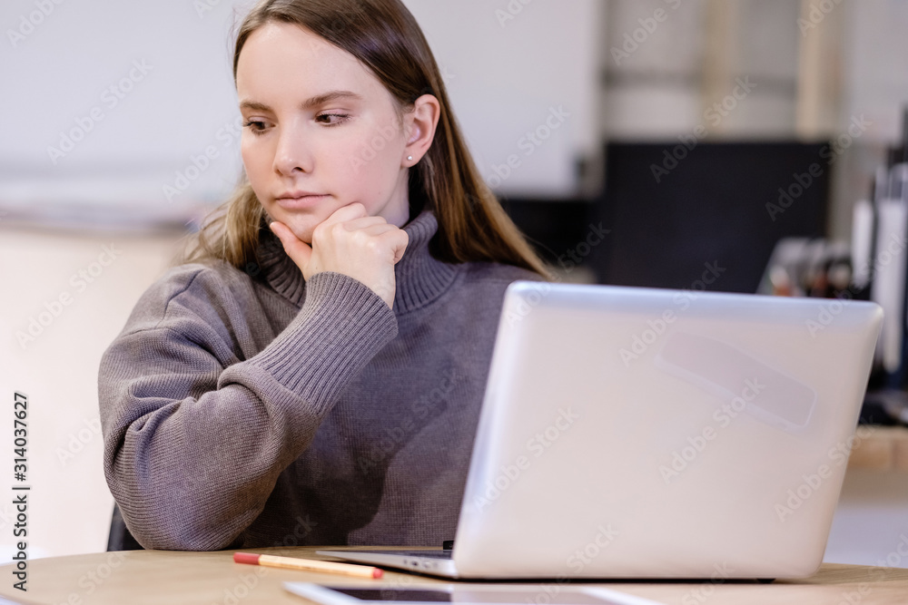 Pensive serious young beautiful woman director of young company in search for customers. ?oncept of hard startup. Pretty young office worker is thinking about business promotion after long working day Pensive serious young beautiful woman director of young company in search for customers. ?oncept of hard startup. Pretty young office worker is thinking about business promotion after long working day