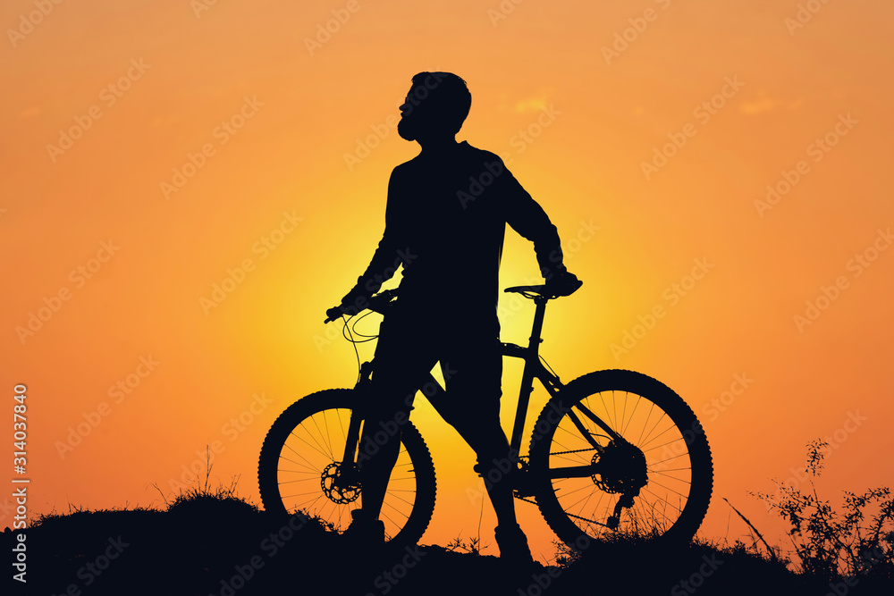Conquering mountain peaks by cyclist in shorts and jersey on a modern carbon hardtail bike with an air suspension fork . Beautiful view from the mountain. Panoramic view for banner. Conquering mountain peaks by cyclist in shorts and jersey on a modern carbon hardtail bike with an air suspension fork . Beautiful view from the mountain. Panoramic view for banner.