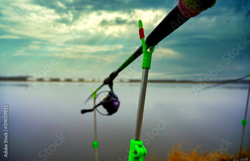 Photo of a fishing rod on an autumn day with morning sun on a quiet river.