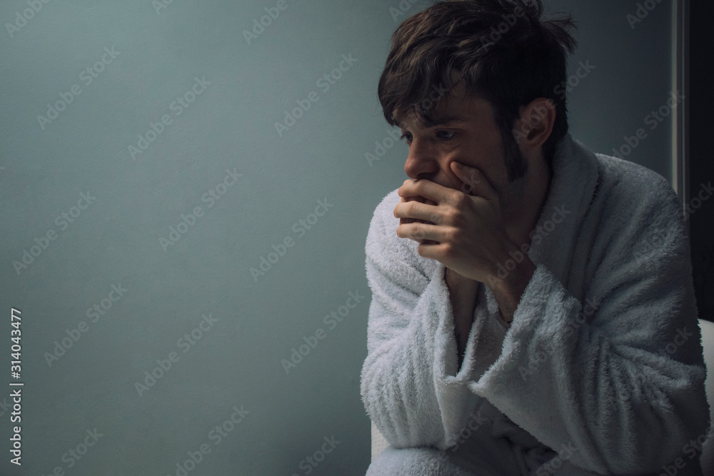 Depressed man in a dark room Depressed man in a dark room