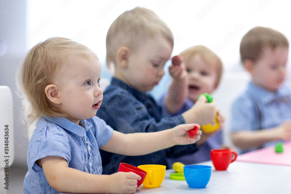 kids group playing with play clay at nursery or kindergarten or primary school kids group playing with play clay at nursery or kindergarten or primary school