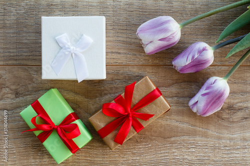 Fototapeta Naklejka Na Ścianę i Meble -  Gift boxes with tulip flower on the wooden background.