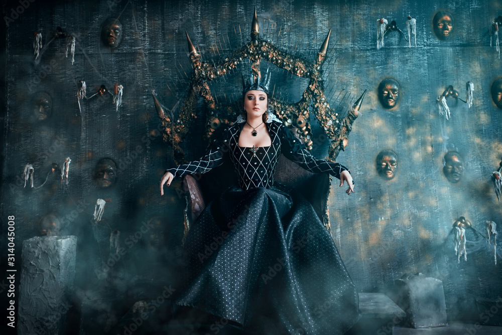 Naklejka premium Evil Queen w czarnej sukience. Piękna dziewczyna w koronie siedzi na tronie