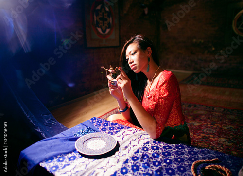 young pretty asian girl in bright colored interior on carpet photo