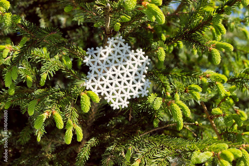 A 3D printed snowflake on a tree branch in summer photo