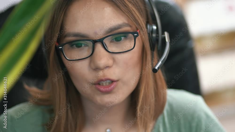 Asian girl works in a call center Asian girl works in a call center