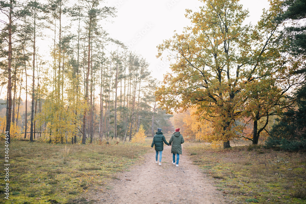 Verliebtes Paar in Winterjacken beim Spaziergang Wandern im Wald Herbst Sonnenuntergang
