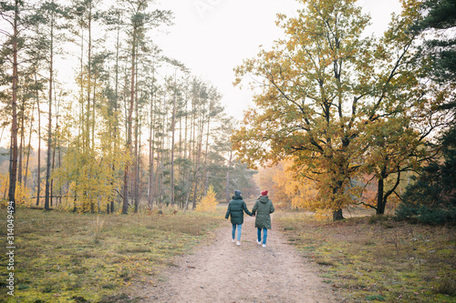 Verliebtes Paar in Winterjacken beim Spaziergang Wandern im Wald Herbst Sonnenuntergang