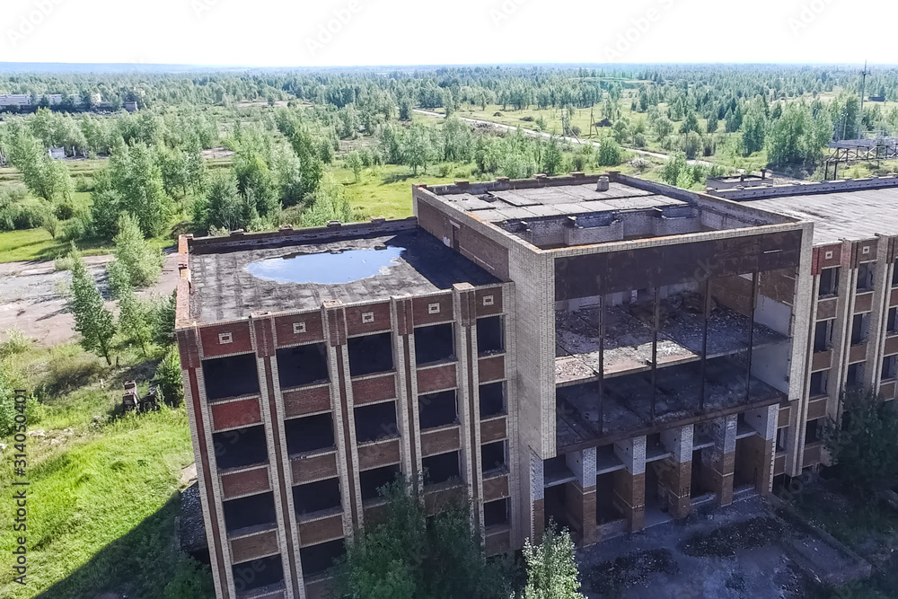 An old abandoned high rise building, overgrown with trees and gr An old abandoned high rise building, overgrown with trees and gr