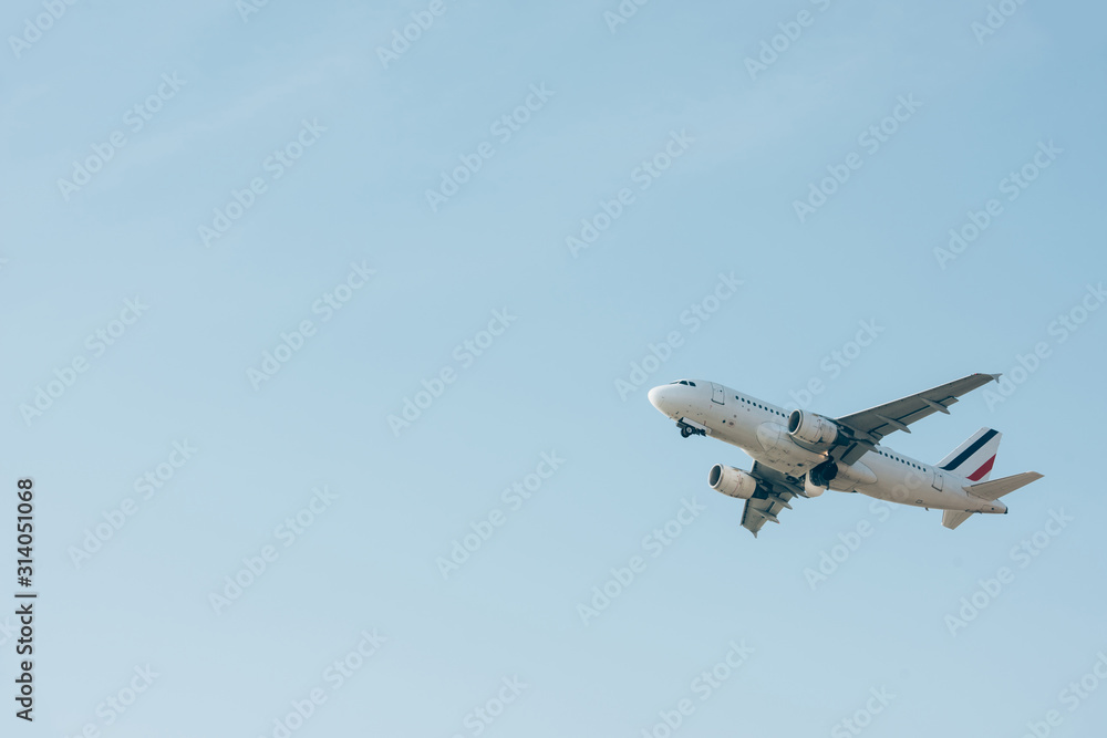 Low angle view of jet plane taking off in blue sky Low angle view of jet plane taking off in blue sky