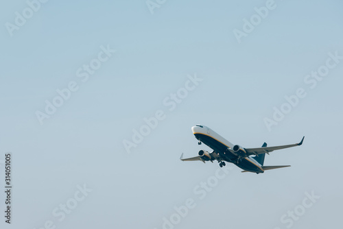 Low angle view of plane taking off in blue sky