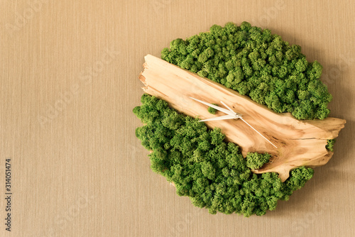 wall clock made of natural materials wood and moss white arrows and place for your text
