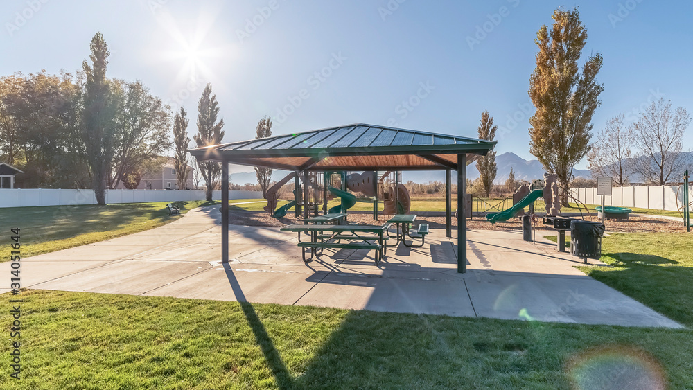 Obraz premium Panorama frame Covered picnic tables and benches near sunrise