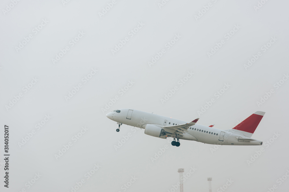 Fototapeta premium Commercial jet plane taking off with cloudy sky at background