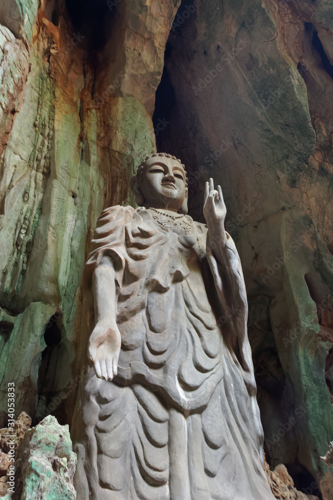 Low angle view of stone Buddha in a cave