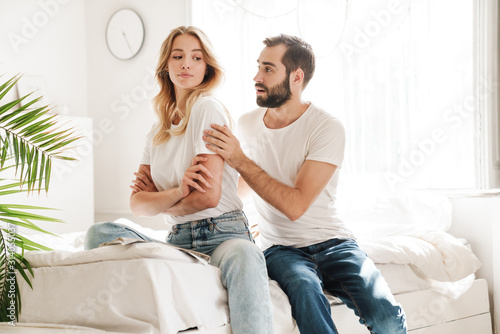 Upset young couple sitting on a couch at the living room