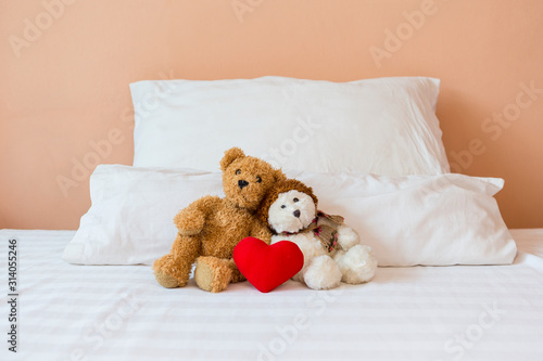 Two cute little teddy bear with red heart on the bed, love and romance concept, valentine background
