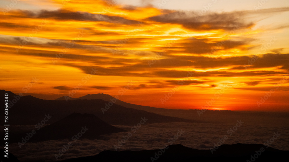 Orange Sky Sunrise with low lying clouds from Mount Bromo with a view of Mount Argopuro and G. Lemongan, Volcanoes in Java, Indonesia Orange Sky Sunrise with low lying clouds from Mount Bromo with a view of Mount Argopuro and G. Lemongan, Volcanoes in Java, Indonesia