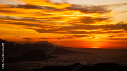 Orange Sky Sunrise with low lying clouds from Mount Bromo with a view of Mount Argopuro and G. Lemongan, Volcanoes in Java, Indonesia
