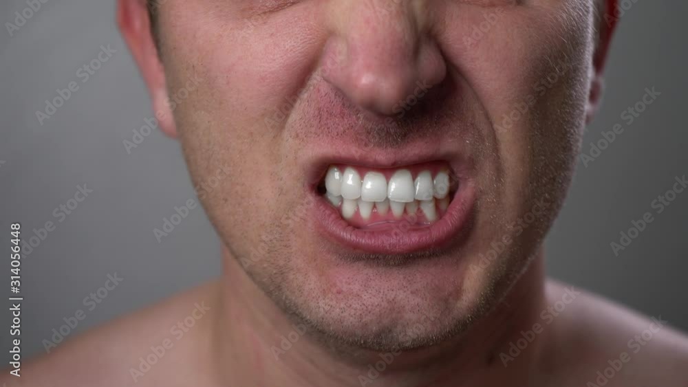 Man with angry facial expression is screaming out loud. Portrait of a shouting man with mouth wide open. Furious yelling man. Anger emotions. Anger. Violence. Mouth and grin close-up. White teeth. Man with angry facial expression is screaming out loud. Portrait of a shouting man with mouth wide open. Furious yelling man. Anger emotions. Anger. Violence. Mouth and grin close-up. White teeth.