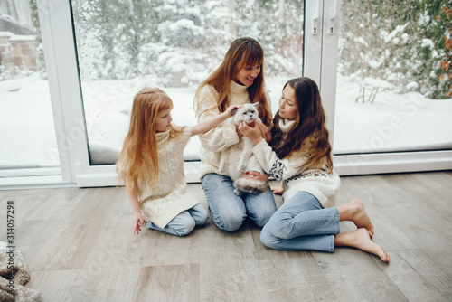 Beautiful mother with children. Family at home. People sitting near winter windows