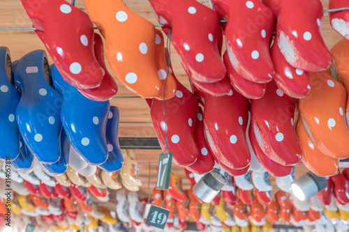 Typical dutch shoes used by farmers. Souvenirs of shoes in different shapes and colors sold in a tourist shop in Amsterdam. Symbol of the Netherlands