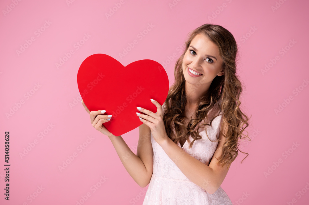 Beautiful woman holding a big, red heart Beautiful woman holding a big, red heart