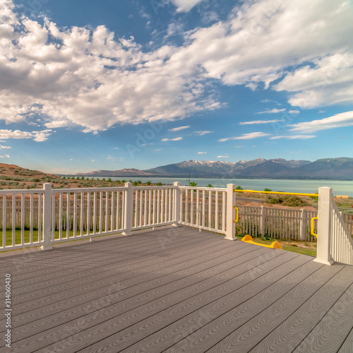 Square frame Back porch of a home with view of lake and mountain under cloudy blue sky
