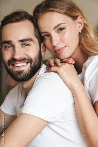 Beautiful happy young couple in love embracing at home