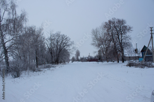 The outskirts of the Russian village of Nikolskoye-on-Cheremshan  winter rural road and forest  winter evening in the Ulyanovsk region in Russia.