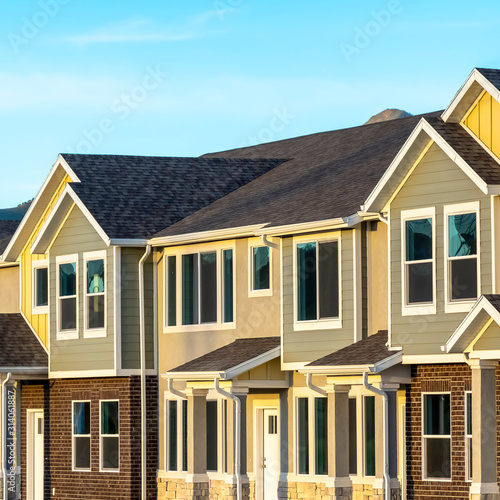 Square Exterior view of townhomes with gable roof stairs and square columns at entrance