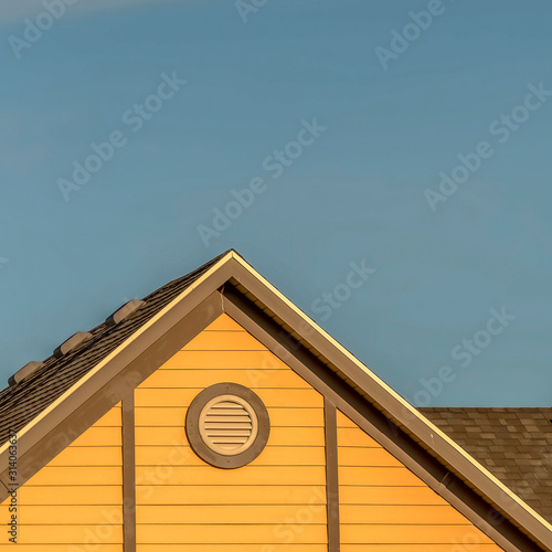 Photography Square frame House exterior with roof shingles and round gable window against bl