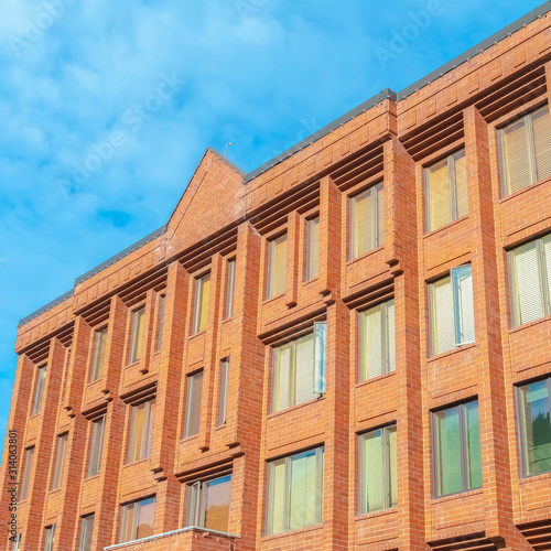 Square frame Exterior of a multi storey building with red brick walls and tall glass windows