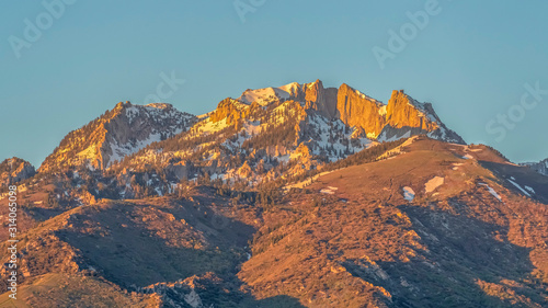 Pano frame Striking mountain peak with rugged slopes against blue sky on a sunny day