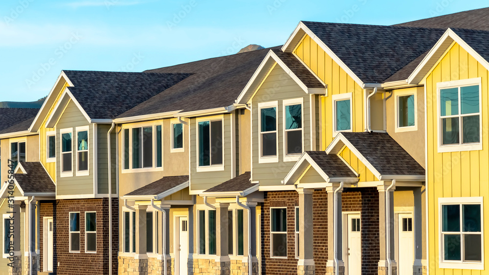 Pano frame Exterior view of townhomes with gable roof stairs and square columns at entrance